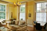 large, light and airy lounge with original wooden shutters to sash windows